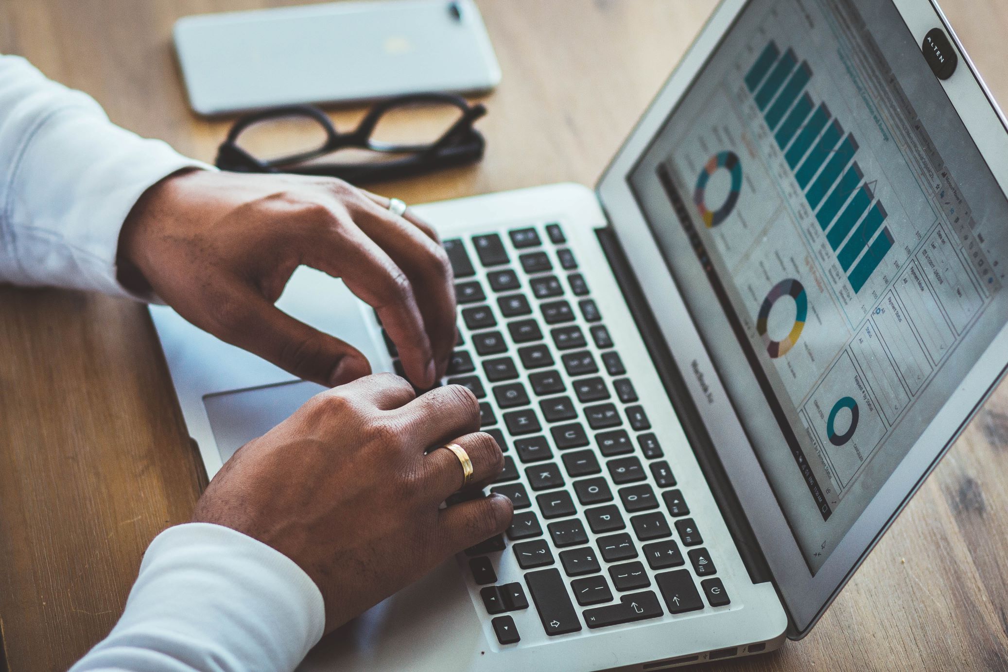 A Person Typing on a Laptop with Key Performance Indicators and RevPar Graphs