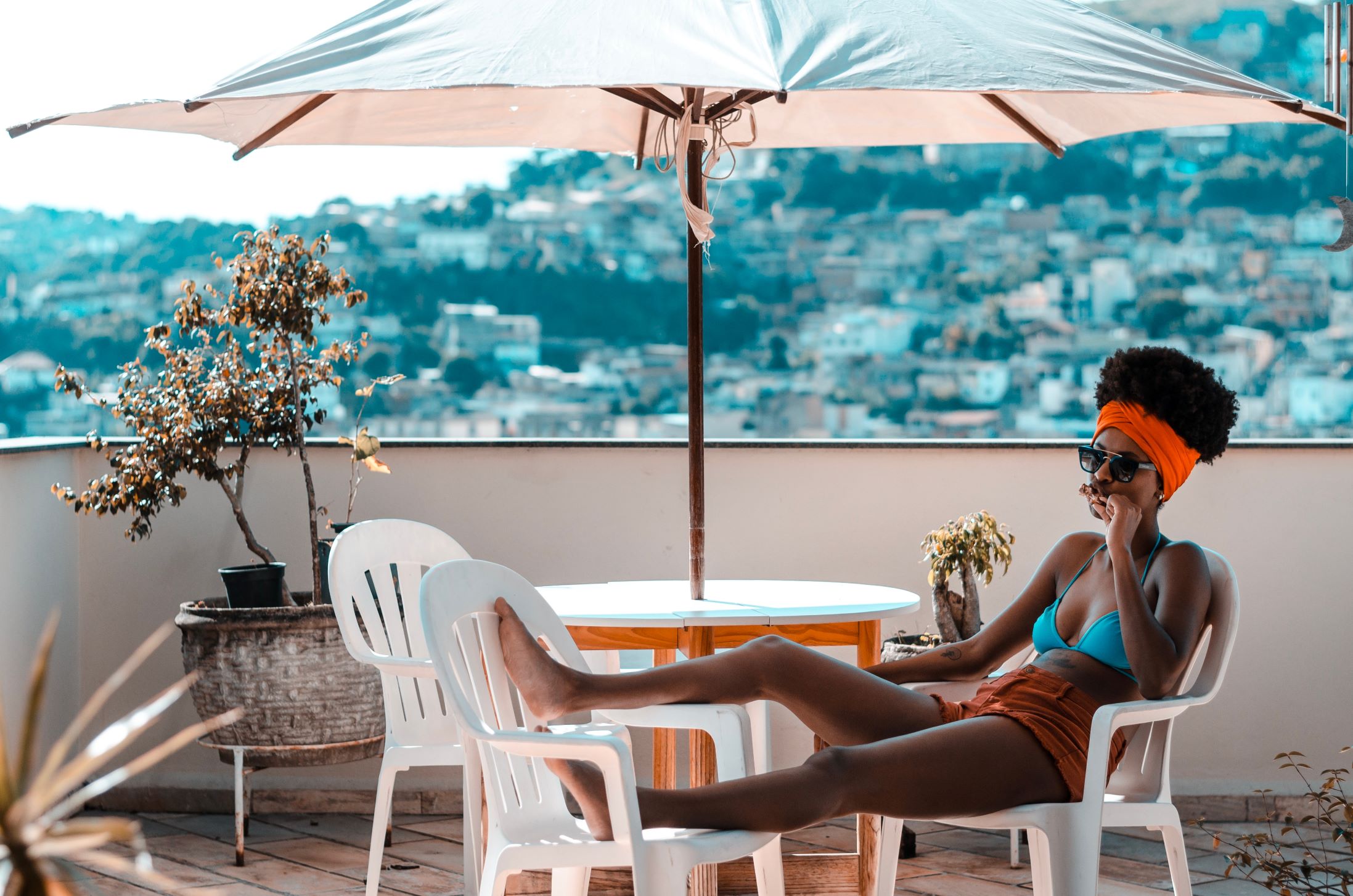 A Woman in a Bikini Enjoying a Short-Term Rental on a Balcony with an Umbrella