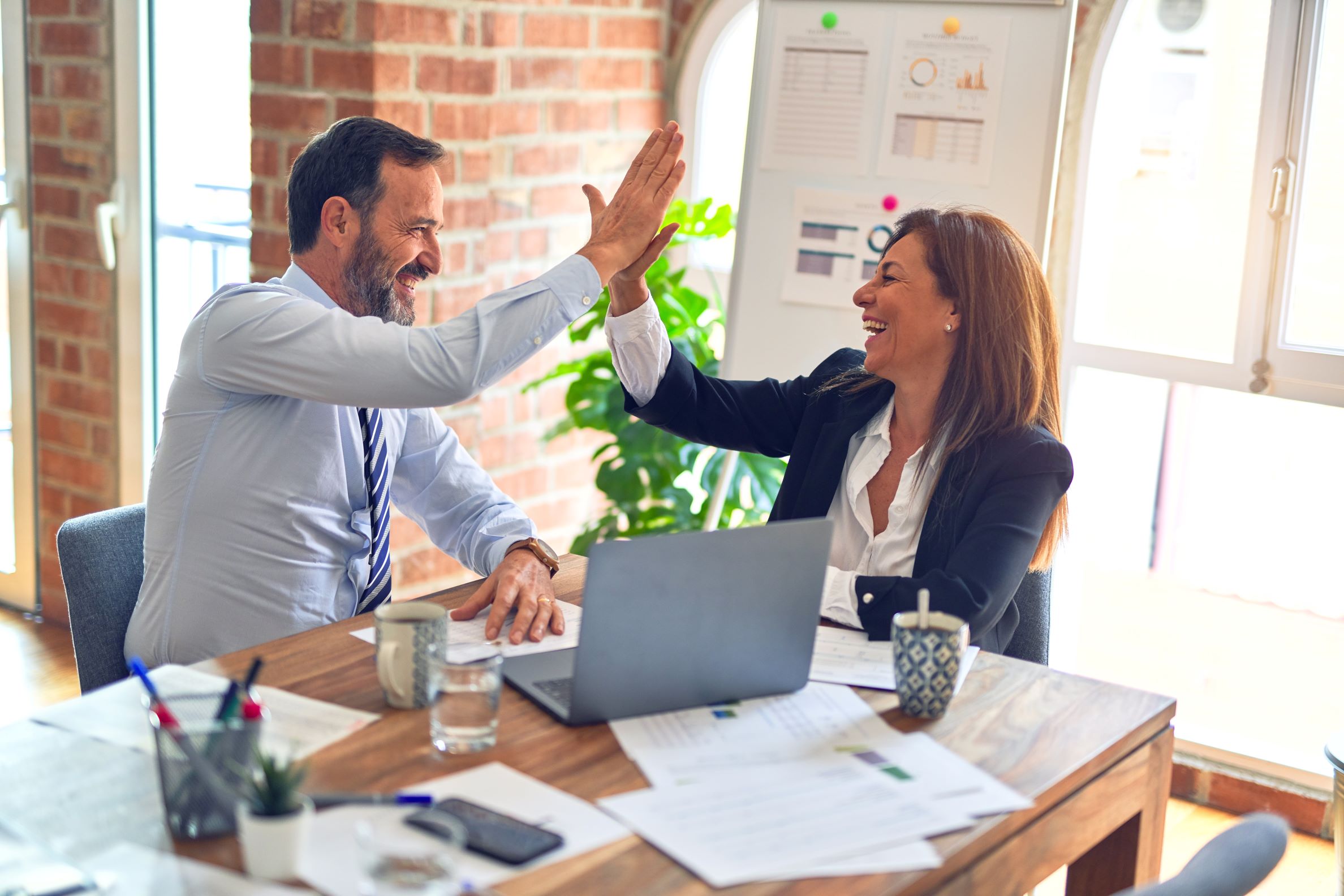 Two Property Managers Celebrating Success in an Office